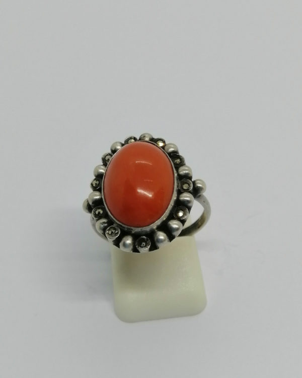 Bague argent de forme ovale, cabochon de corail et marcasites, vers 1920.
