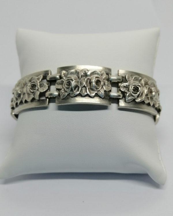 Bracelet argent, avec maillon mobile, et décor de roses et feuilles en relief, vers 1925.