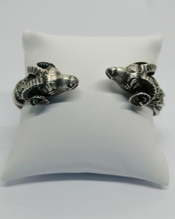Bracelet argent, jonc ouvrant, fil torsadé et têtes de béliers.