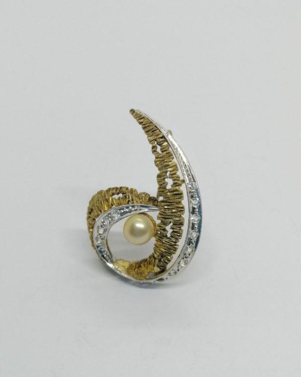 Broche argent bicolore, et sertie de pierres blanches et perle d'imitation.