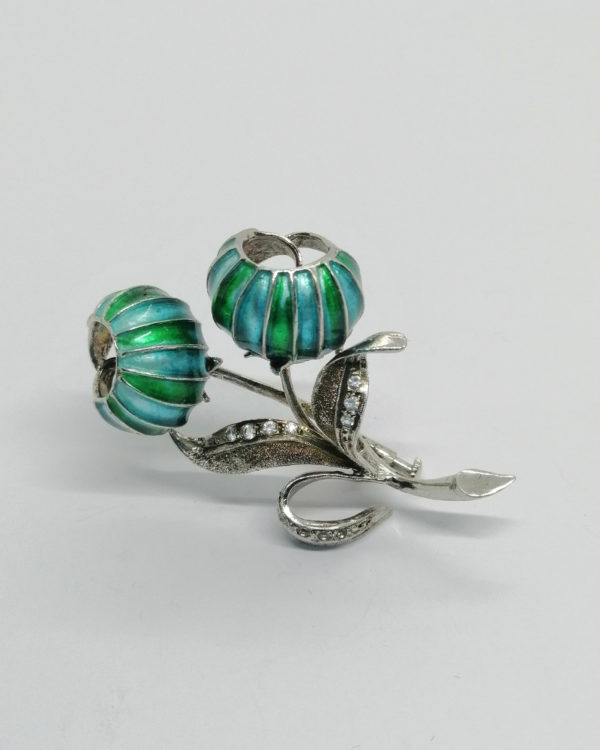 Broche argent, avec fleurs en émail, feuillages et pierres blanches.