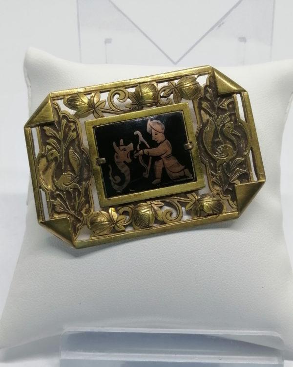 Broche, laiton ajouré, motifs de fleurs, feuilles et oiseaux, scène avec personnage.