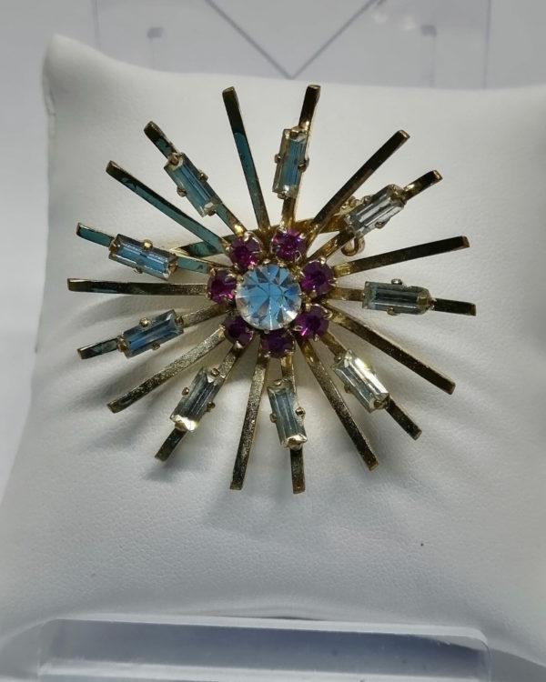 Broche, en forme de soleil, avec sertie de strass baguettes, vers 1930-40.