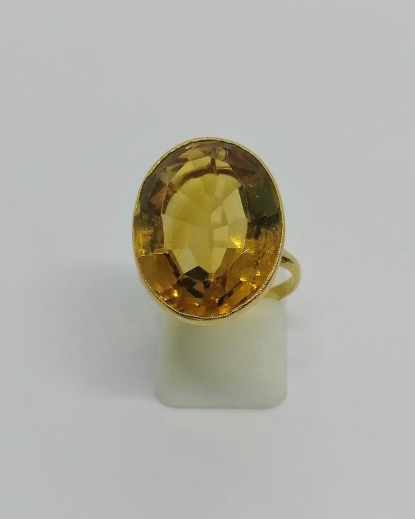 Bague en or jaune, corbeille ajourée et sertie clos d'une grosse citrine ambrée, 1920-30.
