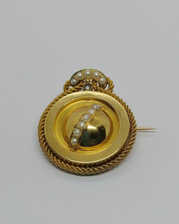 Broche or jaune, fil tourné façon cordelette, et sertie de demi-perles fines, vers 1860-80.