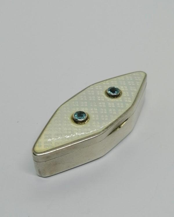 Boîte argent, de forme losangique, émail guilloché, et sertie clos de pierres, vers 1900-20.