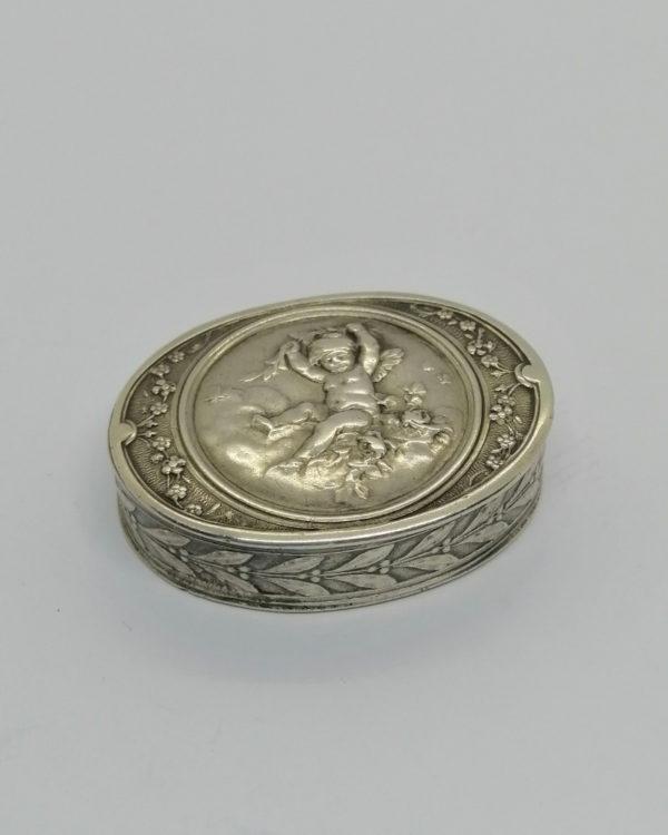 Boîte à pilules, argent, avec motif d'angelot et fleurs, Maison Hénin&Cie à Paris, vers 1900.