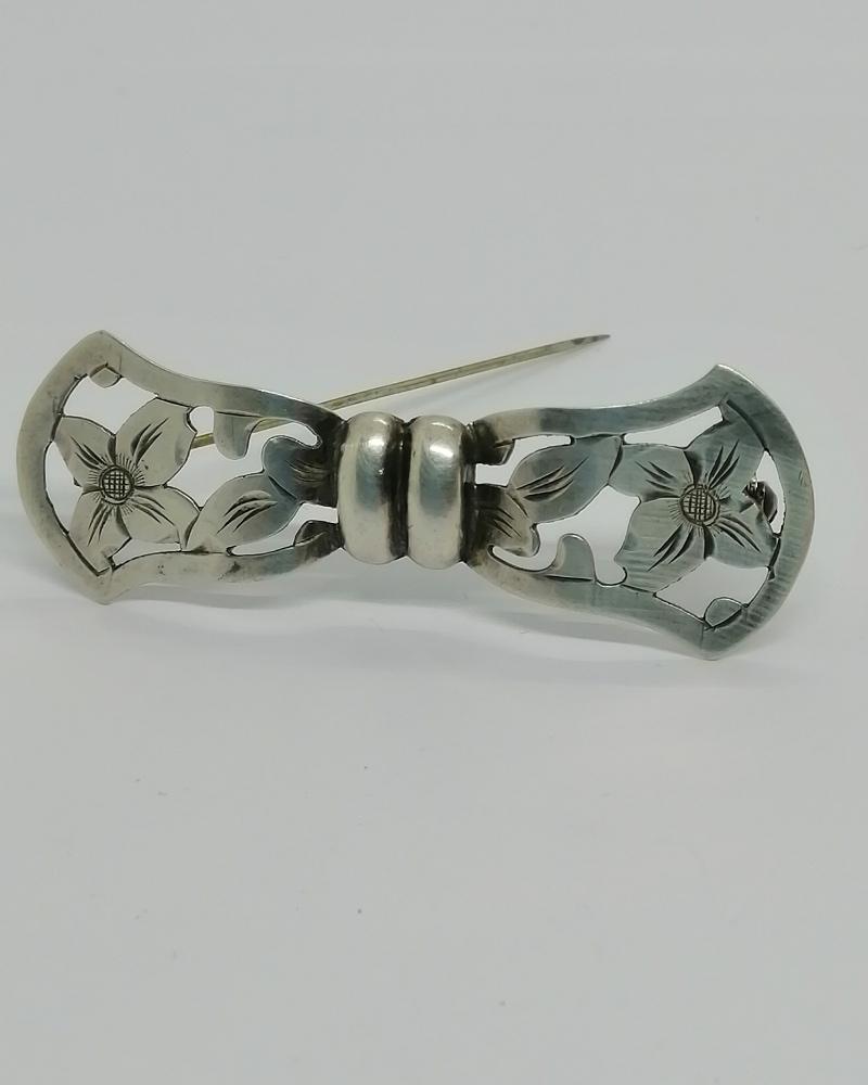 Broche argent, façon noeud ajouré et motif floral, vers 1925-30.