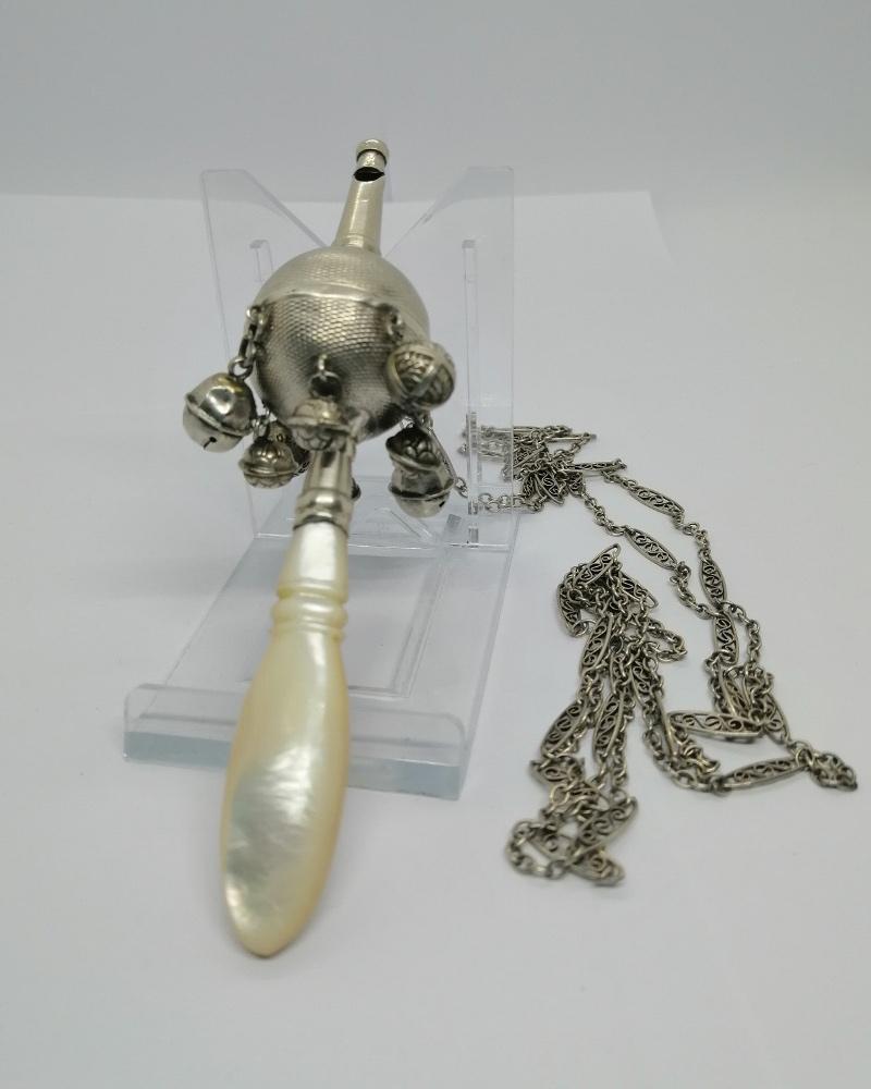 Hochet pour bébé, avec manche en nacre, grelots et sifflet, et sa chaîne, vers 1860.